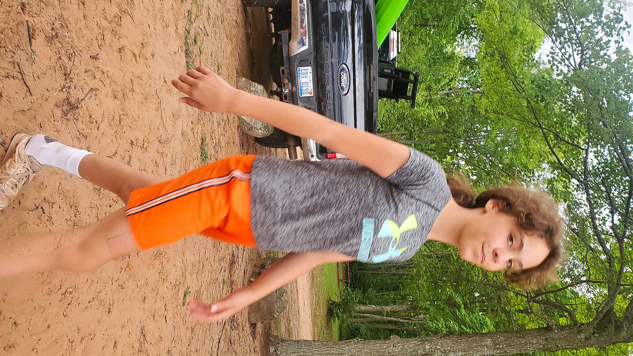 Clarissa is registered to the contest to win money with this photo: car, child, elbow, fun, grass, happy, human_leg, joint, knee, landscape, leisure, natural_environment, people_in_nature, person, plant, recreation, shorts, sport_climbing, t_shirt, thigh