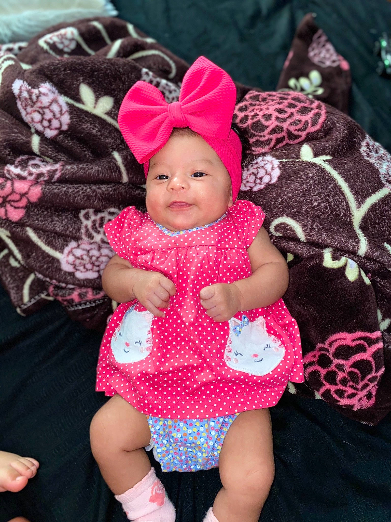 Leticia joined the competition — help win amazing prizes! baby, baby_toddler_clothing, cap, cheek, dress, happy, head, headgear, headwear, magenta, outerwear, pattern, person, pink, purple, skin, sleeve, smile, textile, thigh