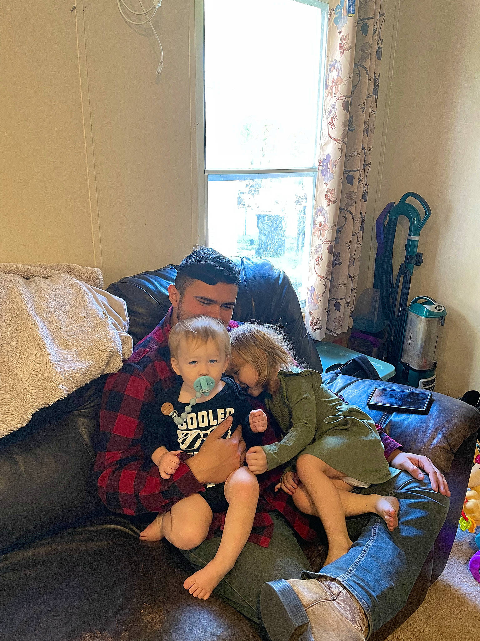 Ernest is registered to the contest to win money with this photo: baby, child, comfort, couch, curtain, floor, flooring, fun, happy, human_leg, leisure, living_room, person, room, shoe, shorts, sitting, sneakers, thigh, toddler