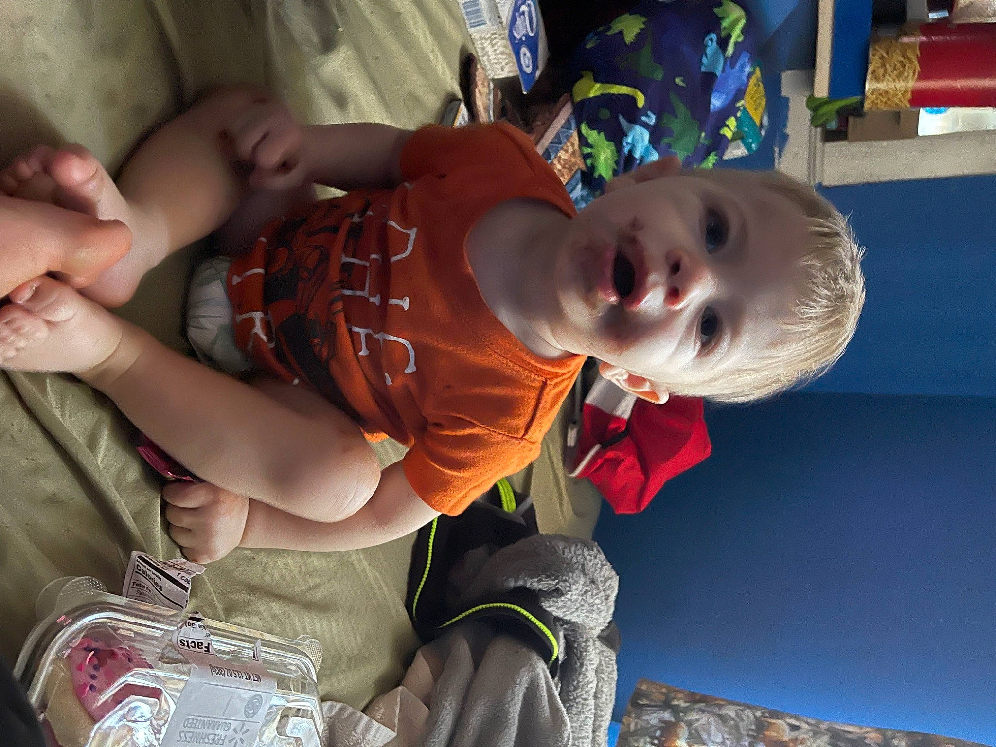 Leon is registered to the contest to win money with this photo: baby, baby_products, baby_toddler_clothing, bag, child, facial_expression, fun, grass, hairstyle, hand, happy, luggage_and_bags, mouth, pattern, person, play, sitting, smile, toddler, vacation