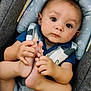 baby, blue_shirt, car_seat, child, comfort, cute, expression, eyes, face, feet, hands, head_support, indoor, infant, person, portrait, seatbelt, skin, striped_shorts, young_child