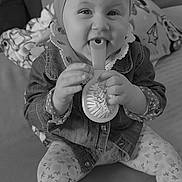 Aina a rejoint le concours — aidez-le/la à gagner de superbes lots ! baby, child, girl, smiling, hairbrush, headband, flower, denim_jacket, leggings, patterned_clothing, indoor, couch, blanket, cushion, happy, playful, sitting, face, portrait, home