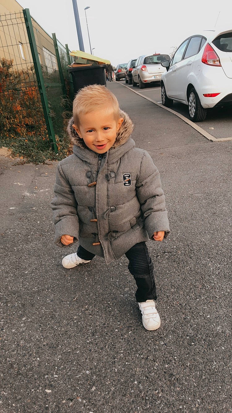 Ethan a rejoint le concours — aidez-le/la à gagner de superbes lots ! asphalt, automotive_design, automotive_exterior, automotive_tire, baby, car, grass, joy, motor_vehicle, parking, person, personal_luxury_car, plant, rim, road, road_surface, sidewalk, tire, toddler, vehicle