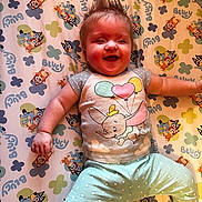 Shelbie is registered to the contest to win money with this photo: arm, baby, balloons, bluey_pattern, cartoon_print, chubby_cheeks, crib_sheet, dumbo_print, happy, infant, leg, lying_down, nursery_bedding, onesie, pastel_colors, playful, polka_dot_pants, portrait, smiling_baby, spiky_hair