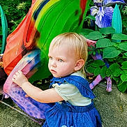 Everly is registered to the contest to win money with this photo: toddler, child, denim_dress, heart_patch, frog_sculpture, colorful, greenery, purple_flowers, outdoor, nature, curious, blonde_hair, portrait, plant, garden, statue, playful, summer, daylight, sculpture