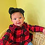 baby, child, headband, bow, red_shirt, checkered, plaid, jeans, wicker_chair, indoor, smiling, cute, portrait, young_child, seated, person, clothing, furniture, face, happy