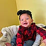 baby, child, smiling, headband, plaid_shirt, denim, basket, blanket, indoor, yellow_wall, happy, cute, sitting, cozy, soft, headwear, infant, person, portrait, warm_lighting