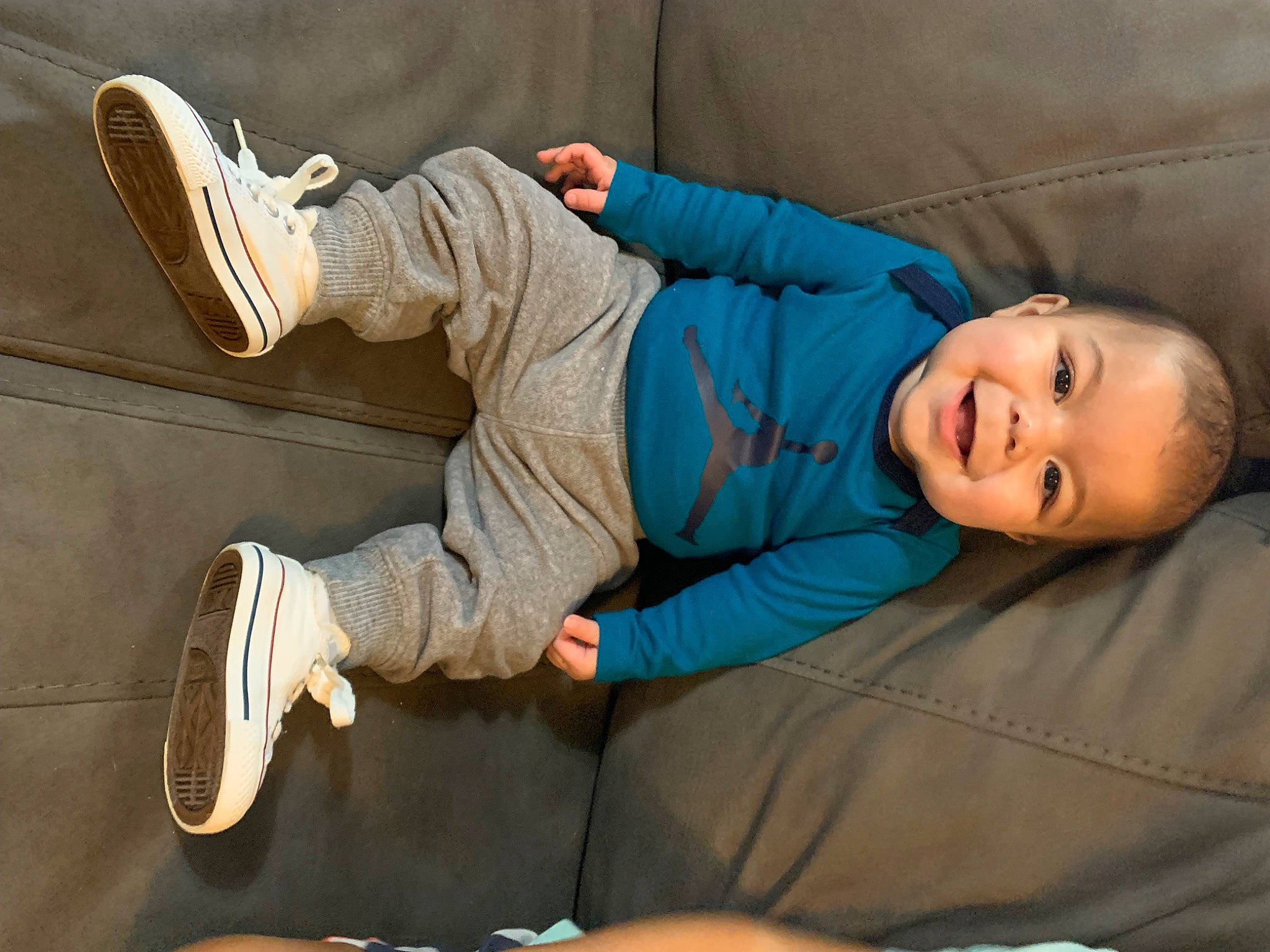 Kyrie is registered to the contest to win money with this photo: athletic_shoe, baby, baby_toddler_clothing, child, comfort, couch, elbow, electric_blue, fun, joint, joy, knee, leg, leisure, outdoor_shoe, person, room, sitting, smile, toddler