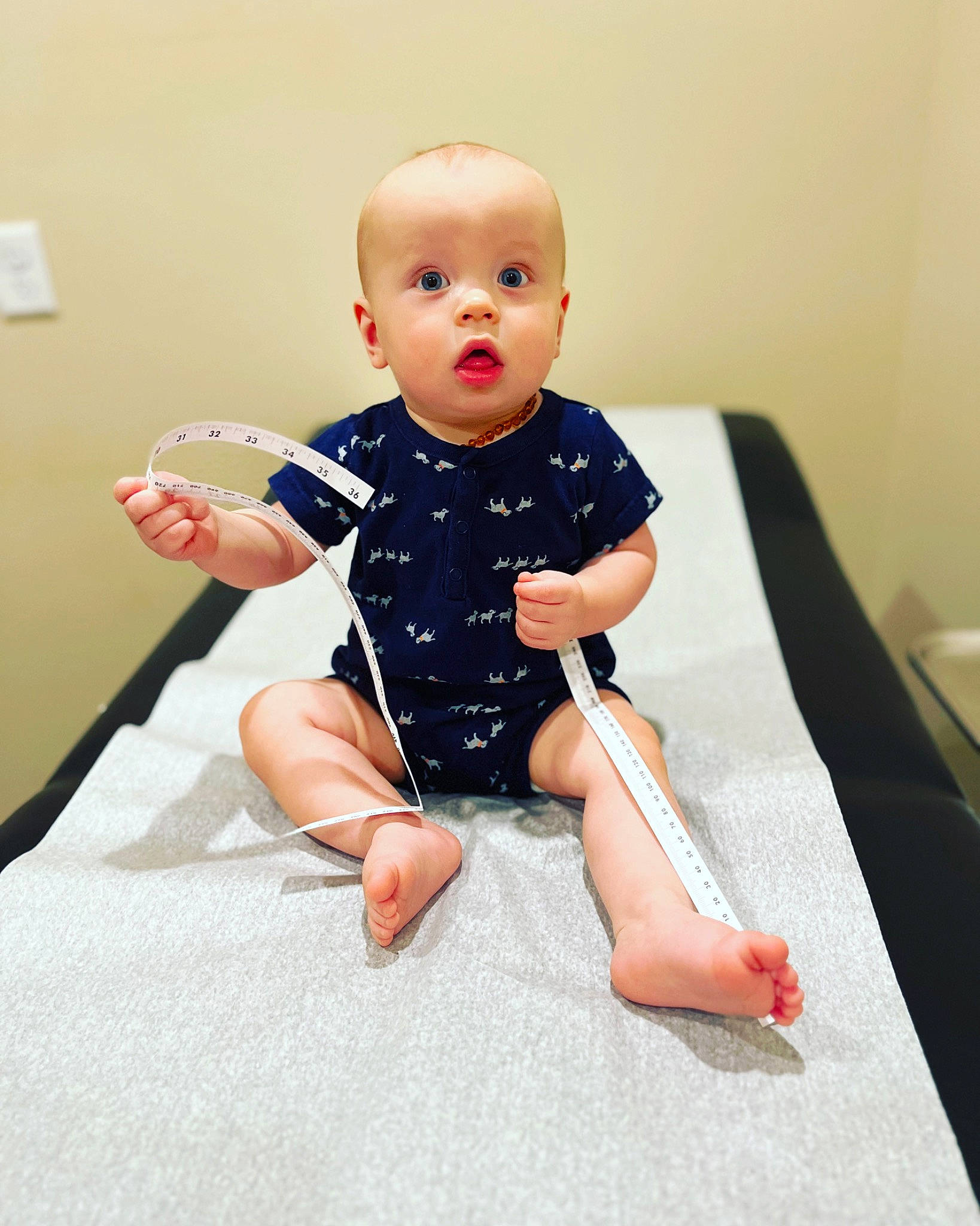 Greyson is registered to the contest to win money with this photo: baby, baby_toddler_clothing, barefoot, child, comfort, elbow, finger, flooring, foot, human_leg, joint, knee, pattern, person, sitting, skin, sleeve, sock, surprise, t_shirt