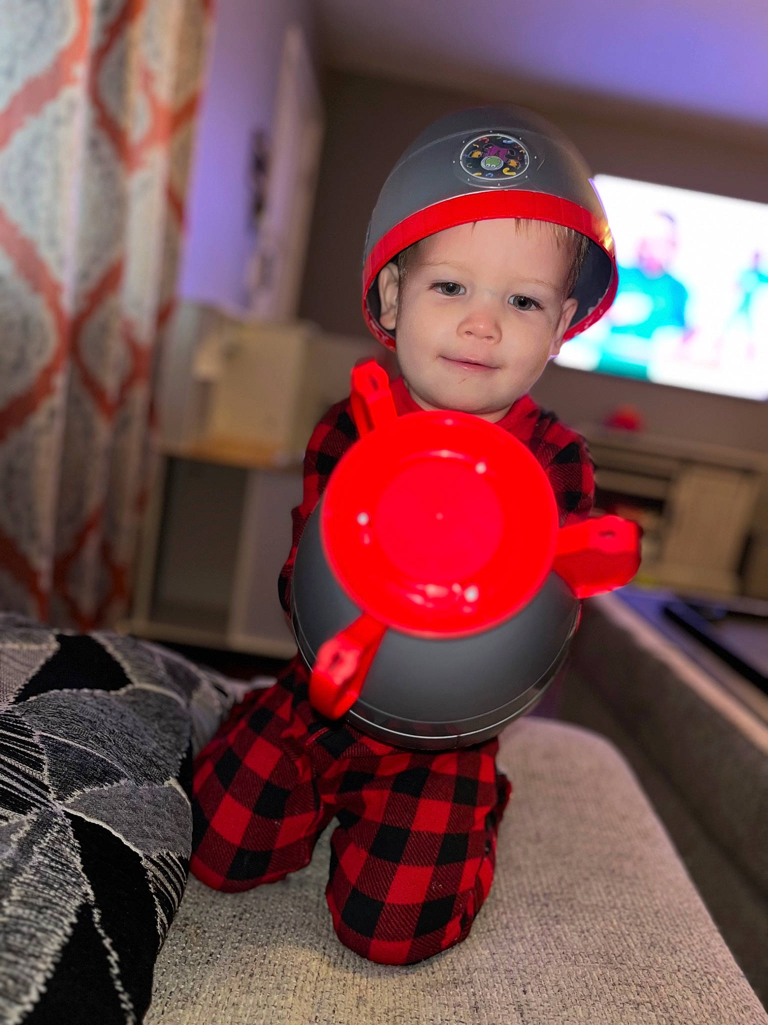 Nicolas is registered to the contest to win money with this photo: arm, audio_equipment, automotive_wheel_system, baseball_cap, carmine, child, costume, fictional_character, flooring, fun, gadget, headwear, helmet, joy, machine, pattern, person, personal_protective_equipment, plaid, tartan