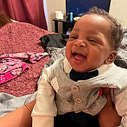 Sincere joined the competition — help win amazing prizes! baby, smiling, laughing, child, indoor, blanket, bed, curtain, television, furniture, clothing, person, happy, portrait, cute, infant, hand, bracelet, cozy, curly_hair