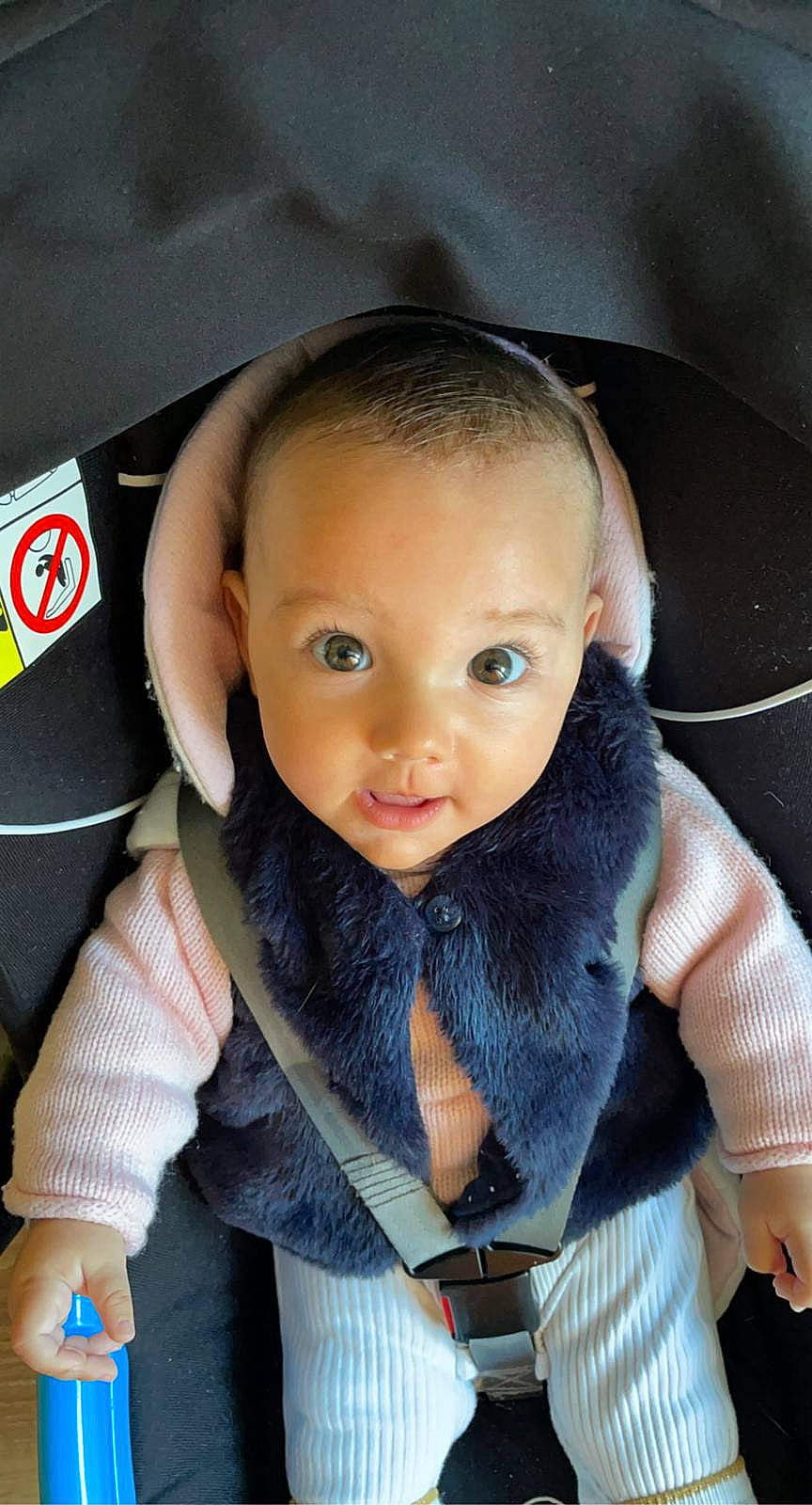 Romy participe au concours pour gagner de l'argent avec cette photo : action_figure, automotive_wheel_system, baby, baby_products, car_seat, cheek, child, doll, electric_blue, eyebrow, eyelash, fashion_accessory, fur, iris, nose, outerwear, person, sitting, smile, textile