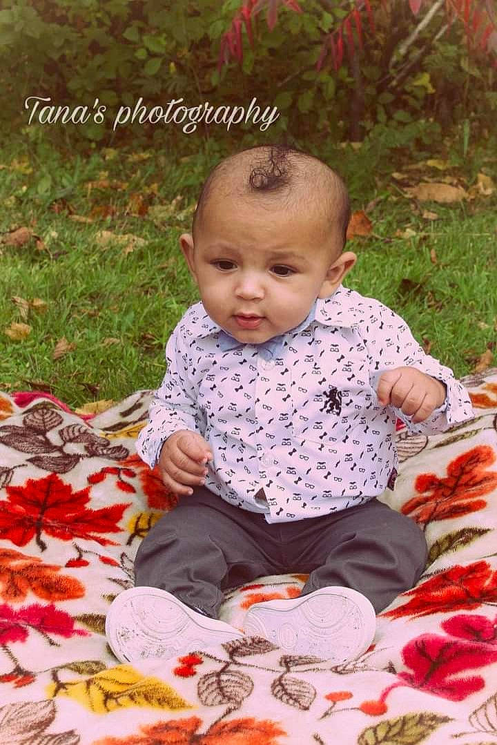 Kendryck joined the competition — help win amazing prizes! baby, baby_toddler_clothing, botany, cheek, child, deciduous, dress, eye, grass, happy, leaf, linens, pattern, people_in_nature, person, petal, plant, portrait_photography, sitting, sleeve