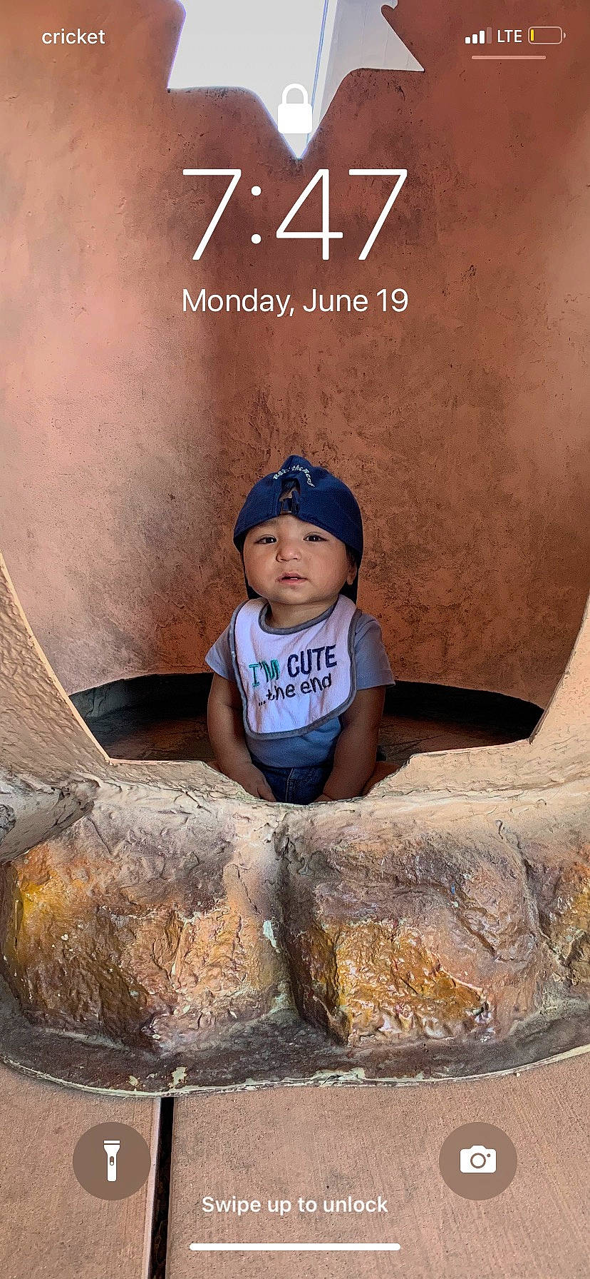 Elias is registered to the contest to win money with this photo: baseball_cap, cap, child, flash_photography, font, fun, happy, hat, headwear, landscape, leisure, logo, person, rock, sand, shorts, sitting, soil, t_shirt, tints_and_shades