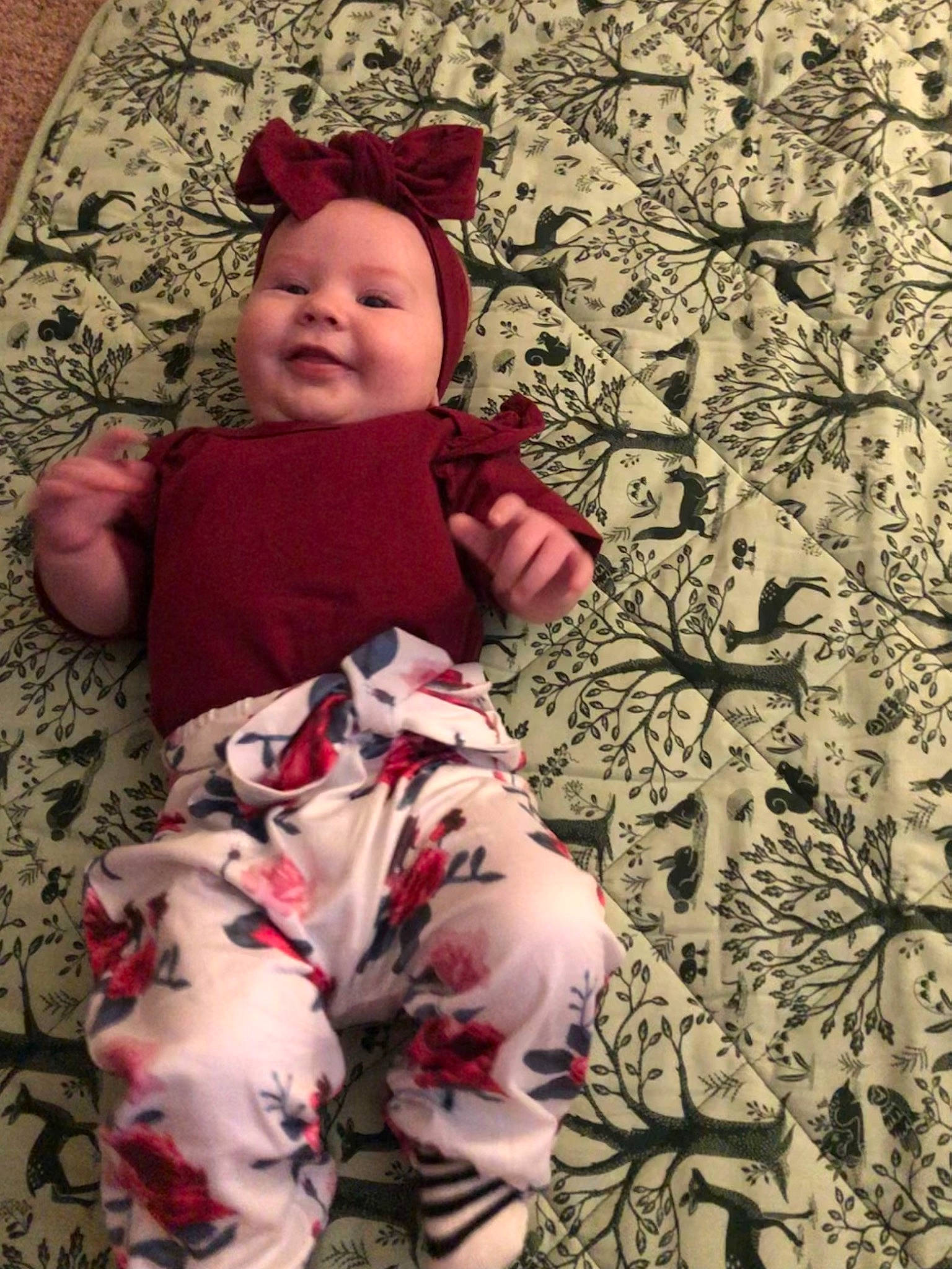 Lucie is registered to the contest to win money with this photo: baby, baby_toddler_clothing, carmine, cheek, child, flooring, happy, headwear, human_leg, joy, linens, magenta, pattern, person, pink, sitting, skin, sleeve, smile, t_shirt