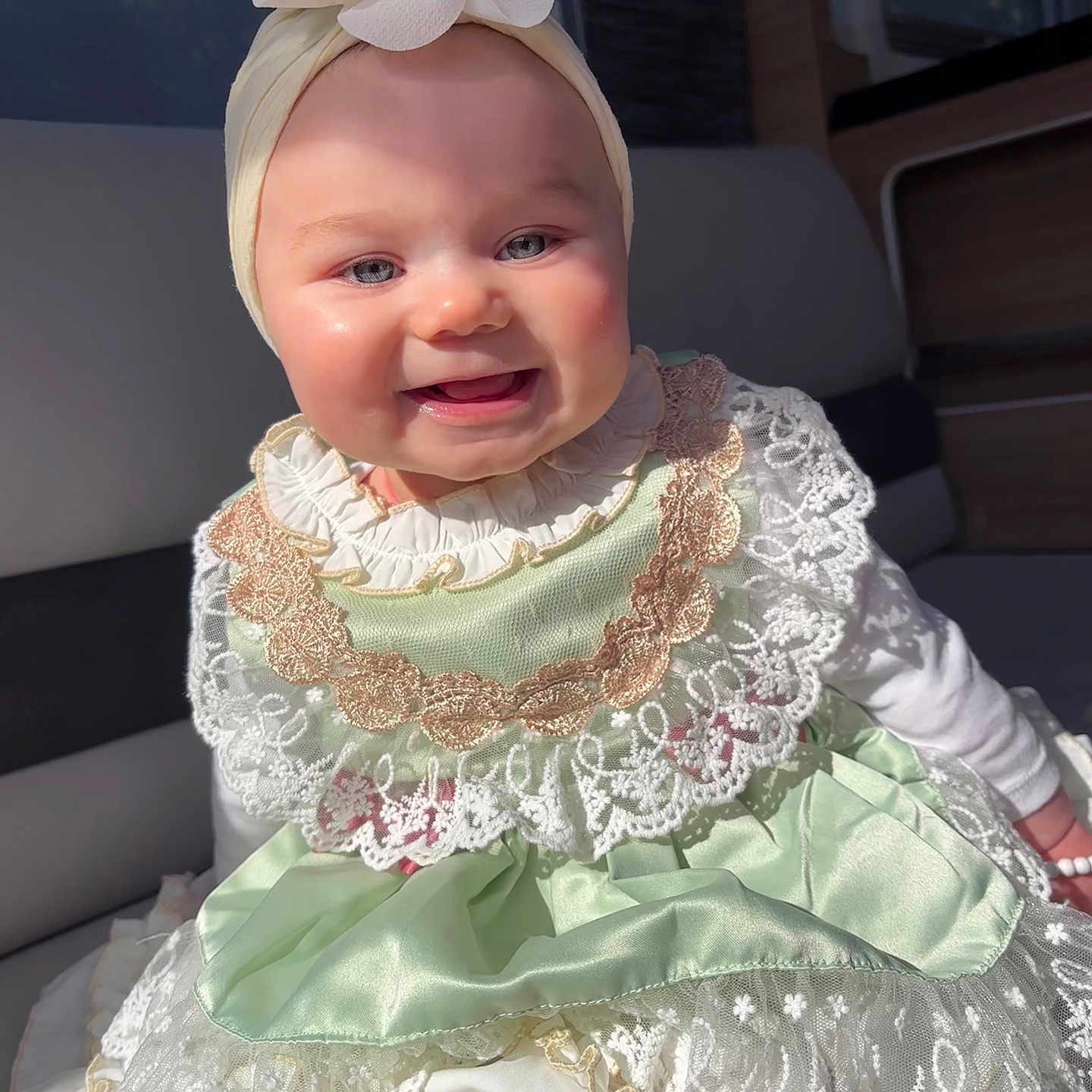 Coraïl participe au concours pour gagner de l'argent avec cette photo : baby, cheeks, child, clothing, cushion, cute, dress, flower, happy, headband, indoors, infant, lace, person, portrait, satin, seat, smile, soft, sunlight