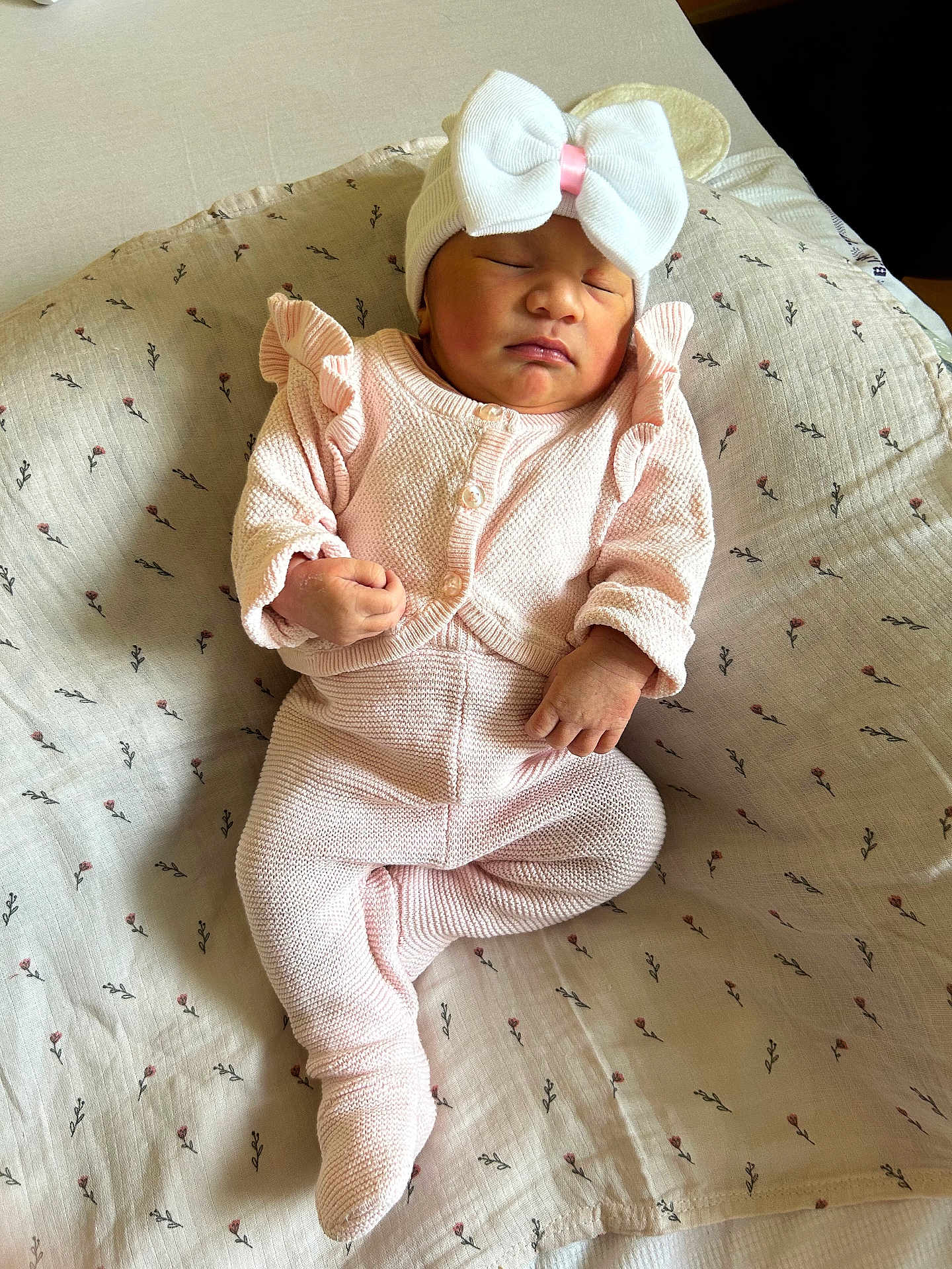 Jenalya a rejoint le concours — aidez-le/la à gagner de superbes lots ! newborn, baby, sleeping, pink_outfit, knitted_clothing, hat, bow, blanket, floral_pattern, infant, cute, peaceful, resting, indoors, soft_texture, child, portrait, small_hands, cozy, lying_down