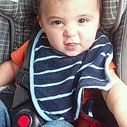 Carson joined the competition — help win amazing prizes! toddler, child, car_seat, bib, striped_bib, orange_shirt, jeans, seatbelt, face, expression, hair, indoor, sitting, person, clothing, baby, cute, funny_face, seat, car_interior