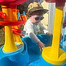 Victor participe au concours pour gagner de l'argent avec cette photo : blue, casual_clothing, child, colorful, exploration, fun, hat, outdoor, person, plastic, playground, red, summer, sunglasses, sunlight, toddler, toy, water, water_play_table, yellow