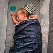 Dominic is registered to the contest to win money with this photo: newborn, baby, sleeping, crib, blanket, hat, pacifier, mesh, infant, resting, cute, child, indoor, cozy, soft, peaceful, portrait, person, young, wrapped