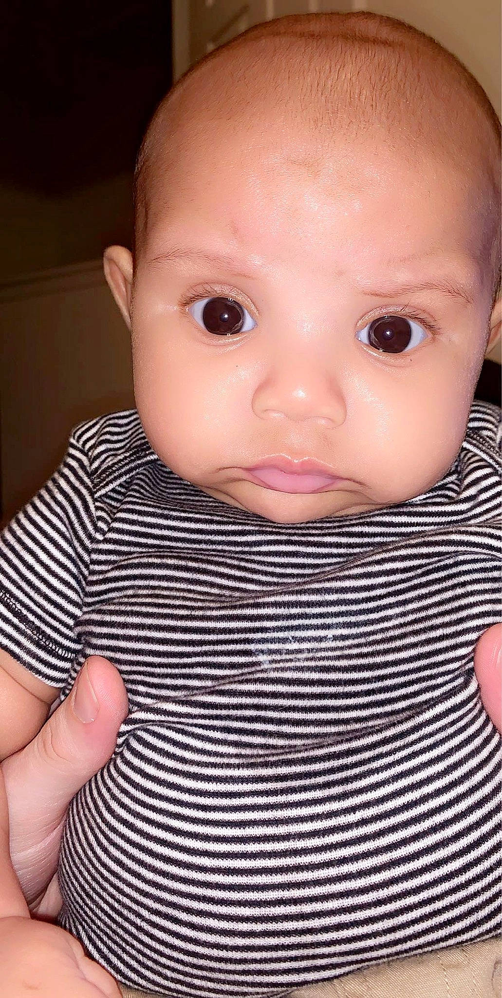 Simba is registered to the contest to win money with this photo: baby, baby_toddler_clothing, cheek, collar, ear, eyelash, finger, gesture, hand, human_body, iris, lip, mouth, nail, neck, no_expression, nose, person, sleeve, thumb