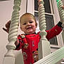 Hayson is registered to the contest to win money with this photo: toddler, child, red_onesie, cartoon_characters, stairs, balusters, white_wood, indoor, window, string_lights, multicolored_lights, smiling, happy, playful, home, baby, person, clothing, face, hand