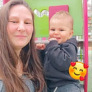 Warren a rejoint le concours — aidez-le/la à gagner de superbes lots ! casual_clothing, child, daylight, emoji, family, fun, green, happy, hoodie, jeans, long_hair, outdoor, person, pink, play_equipment, playground, smiling, swing, toddler, woman