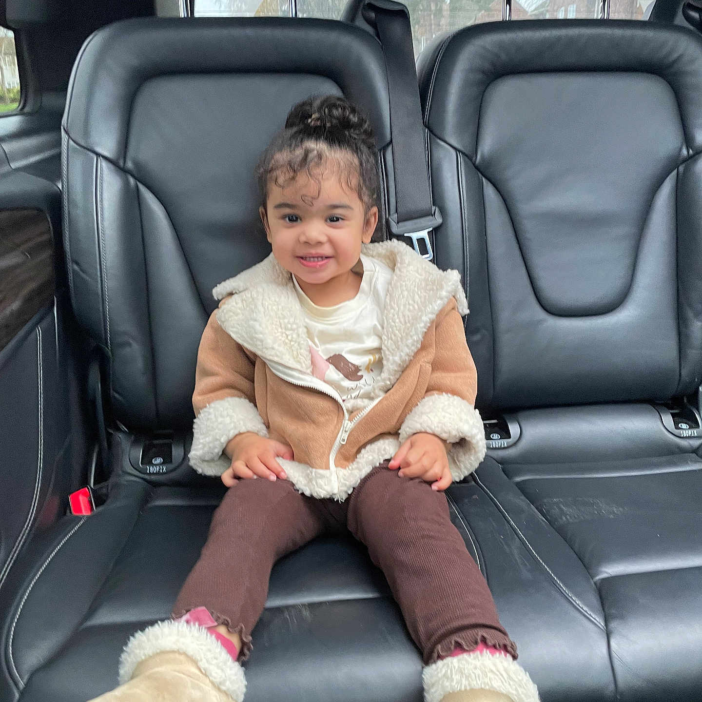 Liyana is registered to the contest to win money with this photo: boots, car_interior, casual, child, clothing, cute, face, hair, happy, indoors, jacket, leather_seat, person, portrait, seatbelt, sitting, smile, toddler, window, young_child