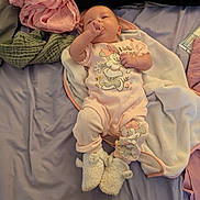 Johannah is registered to the contest to win money with this photo: baby, infant, child, lying_down, sleepy, sucking_fingers, smiling, face, portrait, pink_clothing, pajamas, blanket, bed, stuffed_animal, lamb, minnie_mouse, nursery, indoor, cozy, soft_fabrics