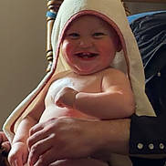 Georgia joined the competition — help win amazing prizes! baby, towel, smile, child, indoor, happy, person, lap, hand, face, skin, seated, wooden_chair, clothing, furniture, room, joy, cute, infant, portrait