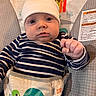 baby, infant, beanie, striped_shirt, blue_and_white, baby_seat, toy_monkey, turtle_graphic, face, hand, wide_eyes, indoor, child, cute, expression, portrait, clothing, seat_harness, bright_starts, looking_at_camera