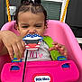 toddler, child, swing, pink, little_tikes, toy, playful, face, hand, hair, pigtails, outdoor, window, green_strap, shirt, expression, person, fun, plastic, seat