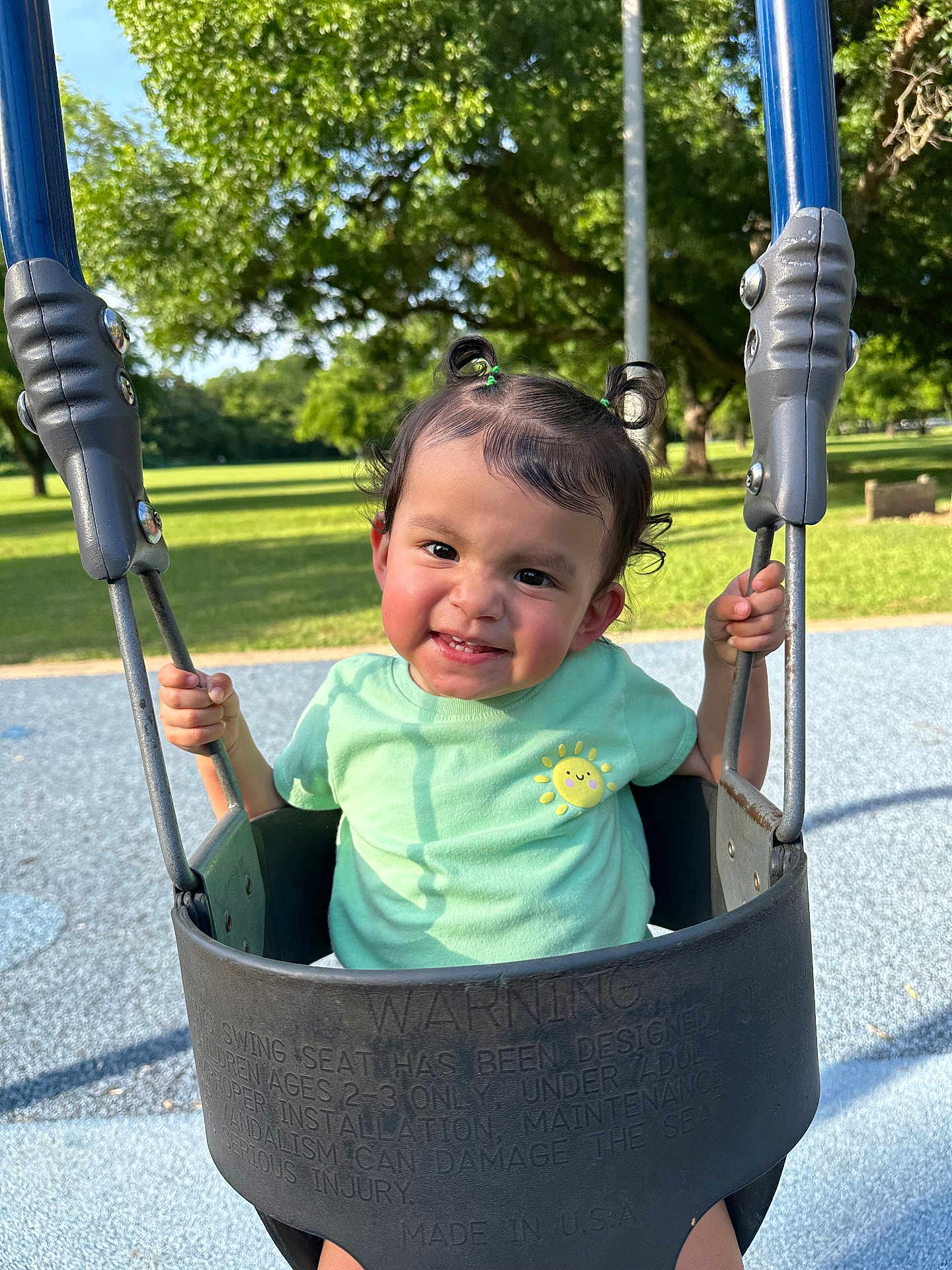 Scarlett joined the competition — help win amazing prizes! toddler, child, baby_swing, playground, park, greenery, trees, grass, sunlight, happy, smiling, pigtails, outdoor, daytime, clothing, person, recreation, fun, cute, nature