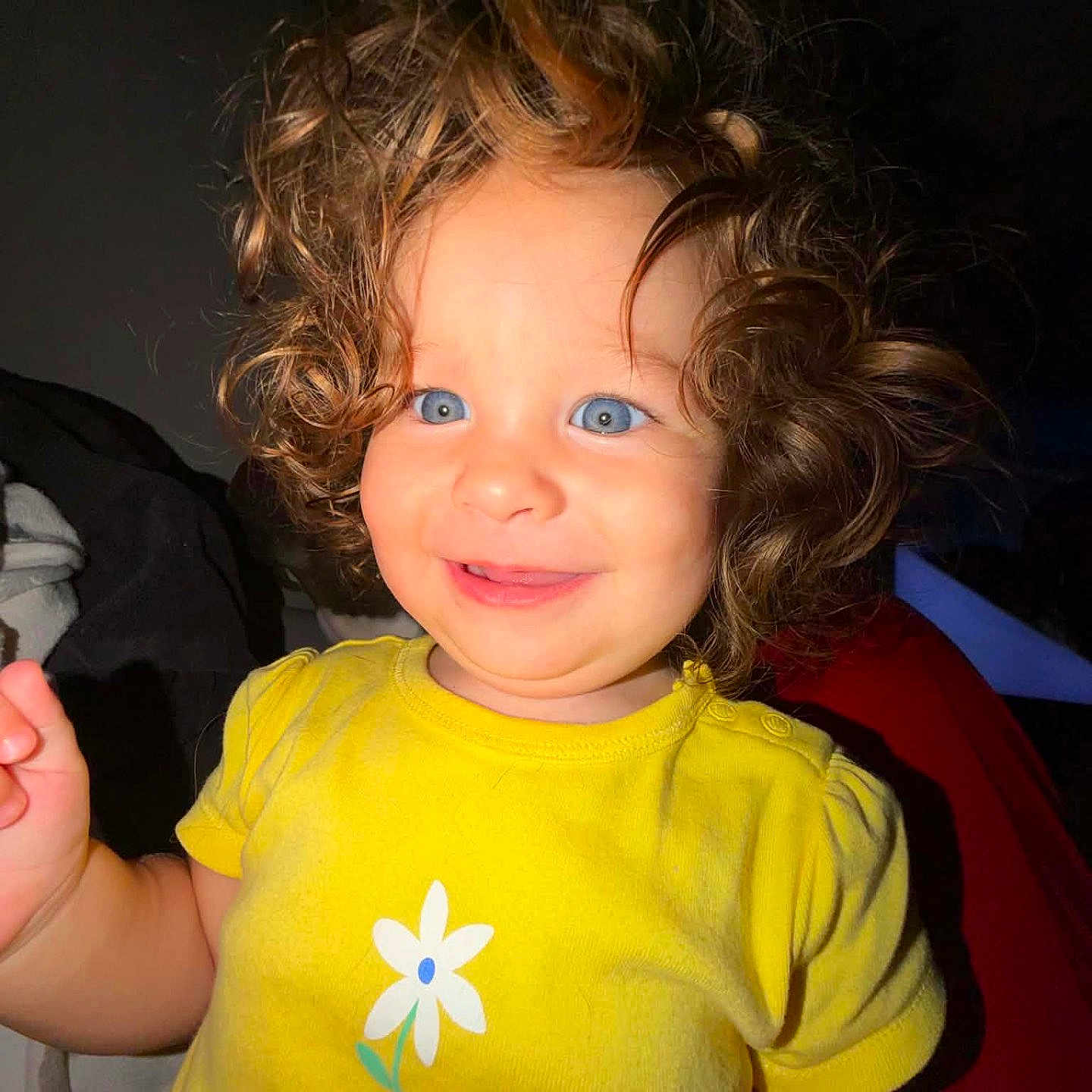 Mackenzie is registered to the contest to win money with this photo: toddler, child, curly_hair, blue_eyes, yellow_shirt, flower_print, smiling, happy, portrait, indoor, baby, person, cute, face, short_sleeves, young_child, bright_colors, innocence, playful, closeup