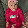 apparel, baby, blanket, braclet, child, couch, cozy, cute, face, fashion, flower, happy, headband, indoors, infant, nike_logo, pink_clothing, portrait, sitting, socks