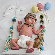 Inaël a rejoint le concours — aidez-le/la à gagner de superbes lots ! baby, infant, diaper, hat, bow_tie, glasses, teddy_bear, flowers, swing, knitted_balloons, white_background, cute, portrait, child, newborn, decor, soft_lighting, playful, resting, handmade
