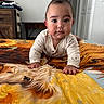 baby, infant, crawling, bedspread, horse_art, indoor, child, portrait, clothing, furniture, wooden_table, blanket, home, person, cute, face, room, decor, table, expression