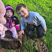 Alistair joined the competition — help win amazing prizes! baby, child, crouching, cute, daylight, footwear, grass, greenery, happy, hat, infant, jacket, nature, outdoor, person, playing, smiling, sunlight, sweater, tree_stump