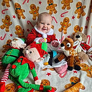 Emilia-Rose is registered to the contest to win money with this photo: baby, child, smiling, santa_outfit, stuffed_toys, elf, reindeer, penguin, blanket, gingerbread_men, candy_canes, holiday, festive, plush, cute, indoors, happy, portrait, seated, red_green