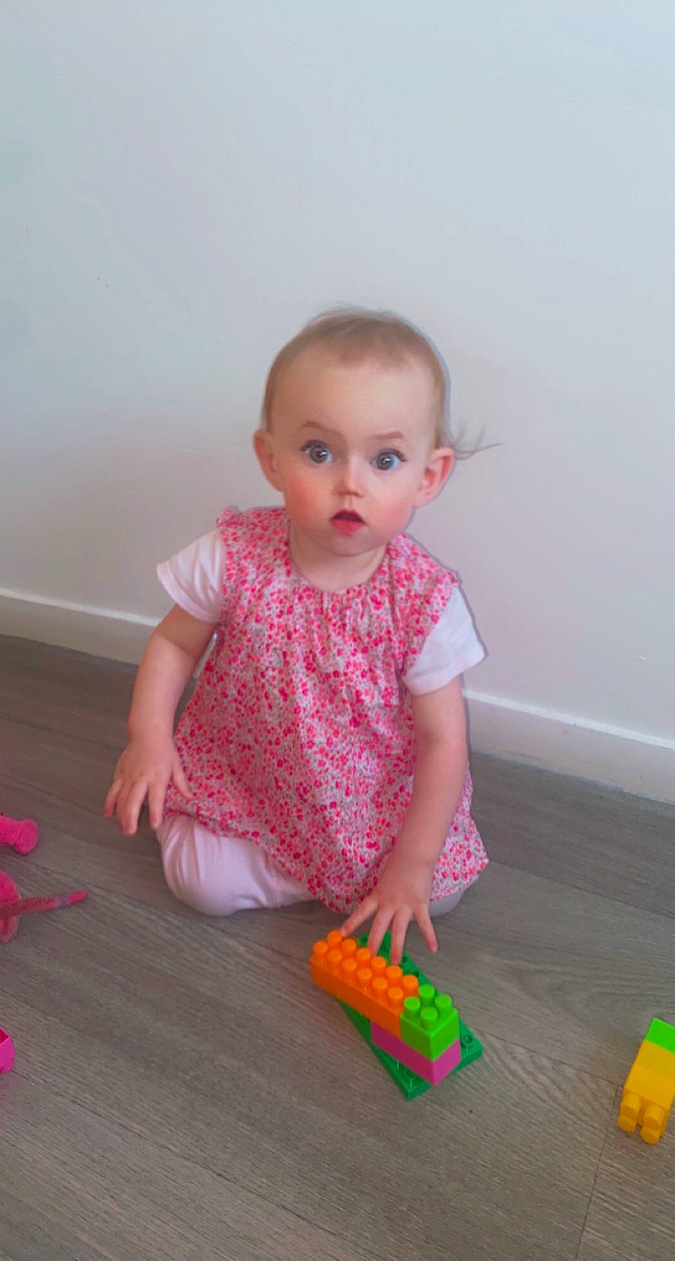 Agathe participe au concours pour gagner de l'argent avec cette photo : baby, baby_playing_with_toys, baby_products, baby_toddler_clothing, cheek, child, finger, floor, flooring, fun, hardwood, pattern, person, pink, play, sitting, skin, sleeve, surprise, toddler