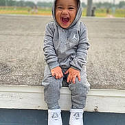 Nicolas joined the competition — help win amazing prizes! toddler, child, smiling, laughing, hoodie, sweatpants, sneakers, grey_clothing, outdoor, bench, happy, casual, young_child, sitting, joyful, person, footwear, urban, daytime, portrait
