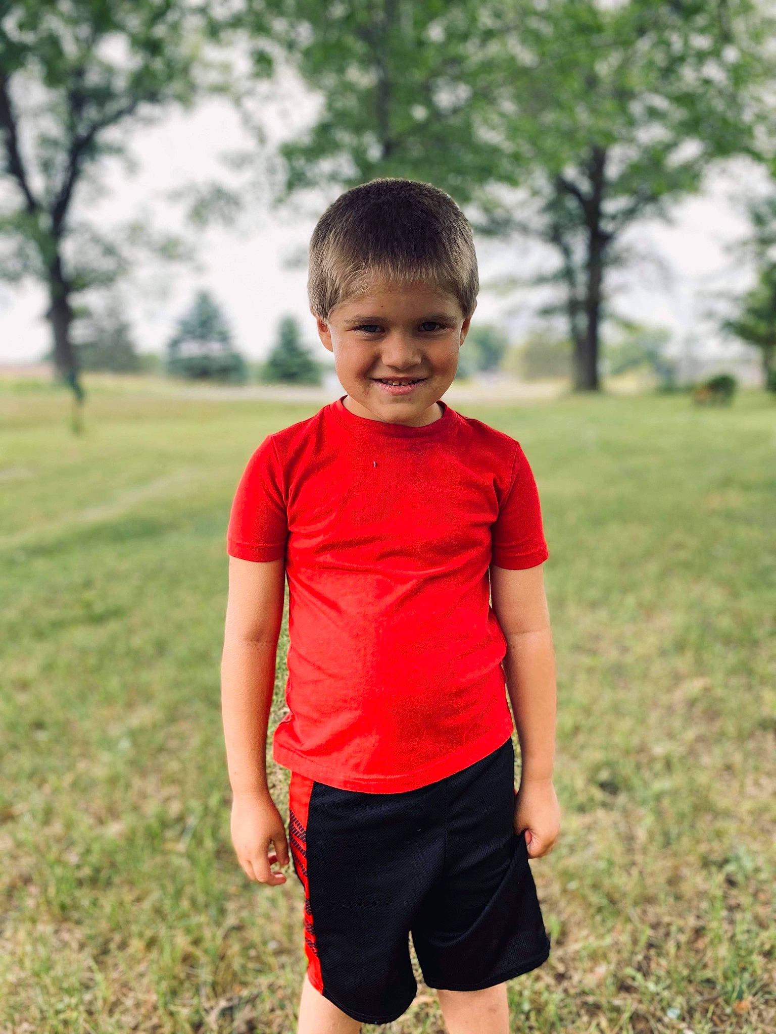 Micheal is registered to the contest to win money with this photo: child, face, grass, joy, leisure, people, person, photography, plant, play, recreation, red, running, shorts, sleeve, smile, spring, summer, t_shirt, toddler