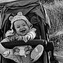 Leyna participe au concours pour gagner de l'argent avec cette photo : baby, stroller, smile, happy, hoodie, toy, outdoor, grass, sea, water, footwear, infant, clothing, nature, child, playful, black_and_white, portrait, person, seat