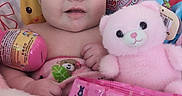 Ruby is registered to the contest to win money with this photo: baby, infant, teddy_bear, marshmallow_candy, peeps, pink, toy, seat, colorful, cute, child, smiling, soft, plush, candy, packaging, face, person, indoors, closeup