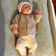 Maël participe au concours pour gagner de l'argent avec cette photo : baby, pacifier, blanket, knitwear, hat, sleeping, infant, clothing, footed_pants, bed, shadow, indoor, cute, newborn, person, soft_texture, resting, child, warm_clothes, lying_down