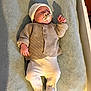 baby, pacifier, blanket, knitwear, hat, sleeping, infant, clothing, footed_pants, bed, shadow, indoor, cute, newborn, person, soft_texture, resting, child, warm_clothes, lying_down