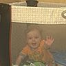 Noah joined the competition — help win amazing prizes! baby, bright, child, cozy, crawling, cute, floor, furniture, happy, home, indoor, infant, mesh, netting, orange_shirt, person, playpen, smiling, toy, waving