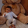 baby, teddy_bear, plush, child, indoor, cute, soft_toy, smile, thumbs_up, bedspread, white_shirt, pants, barefoot, furniture, room, cozy, comfort, portrait, young_child, toy