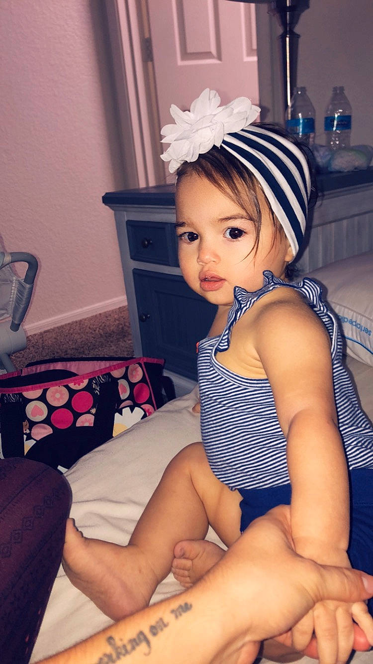 Anabella is registered to the contest to win money with this photo: arm, black_hair, clothing, finger, headgear, human_leg, leg, neck, person, sitting, thigh