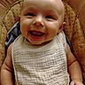 Makenzie joined the competition — help win amazing prizes! baby, smiling, bib, cushion, chair, infant, happy, portrait, child, skin, clothing, sitting, cute, person, head, face, expression, indoors, young, joyful